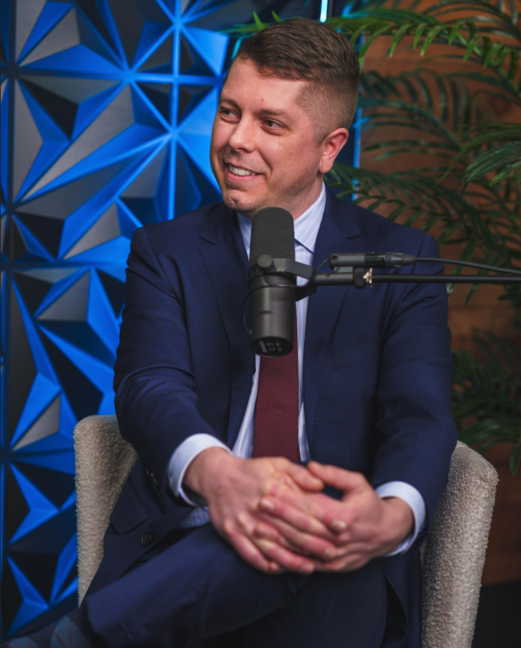 Guest in a suit speaking into a studio microphone
