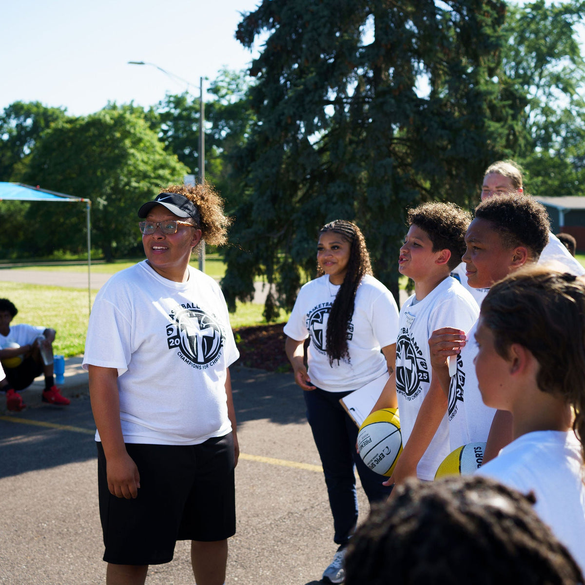 coach speaking with young athletes at a Lansing basketball camp